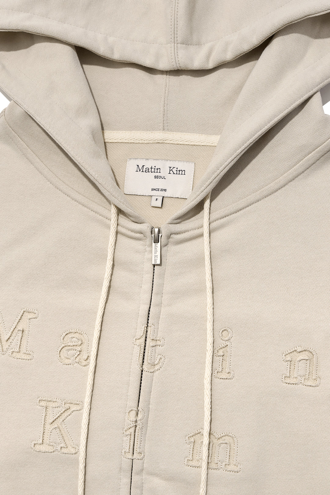 Matin Kim Appliqué Cutout Logo Zip Hoodie — Beige