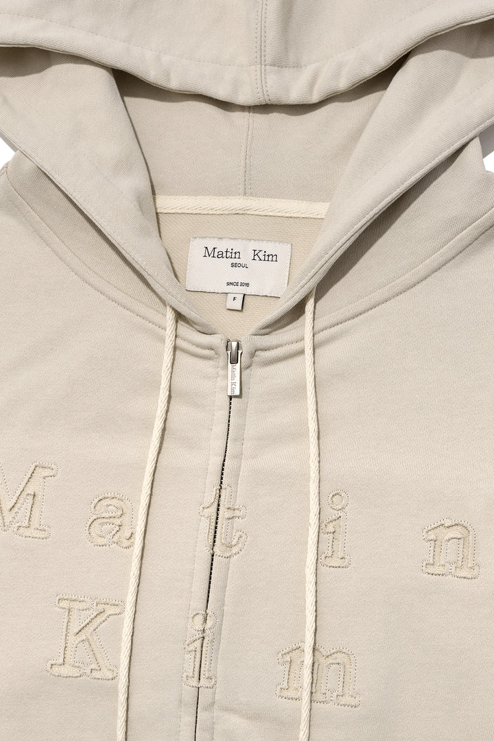 Matin Kim Appliqué Cutout Logo Zip Hoodie — Beige